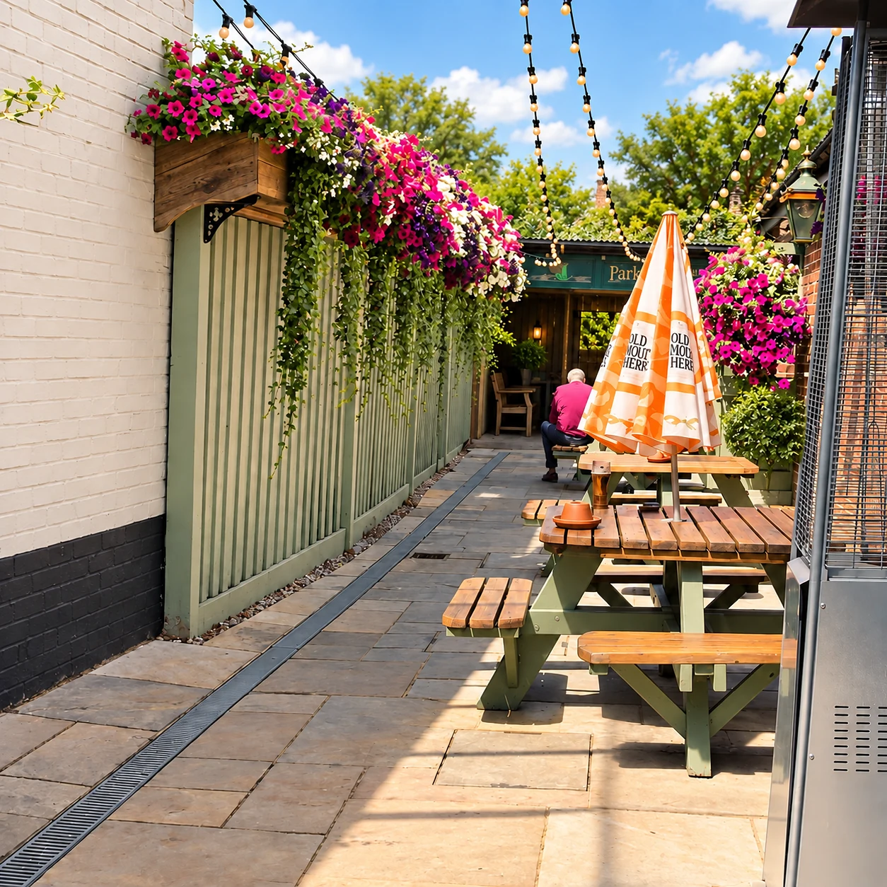 Flower-filled courtyard with wooden tables and string lights