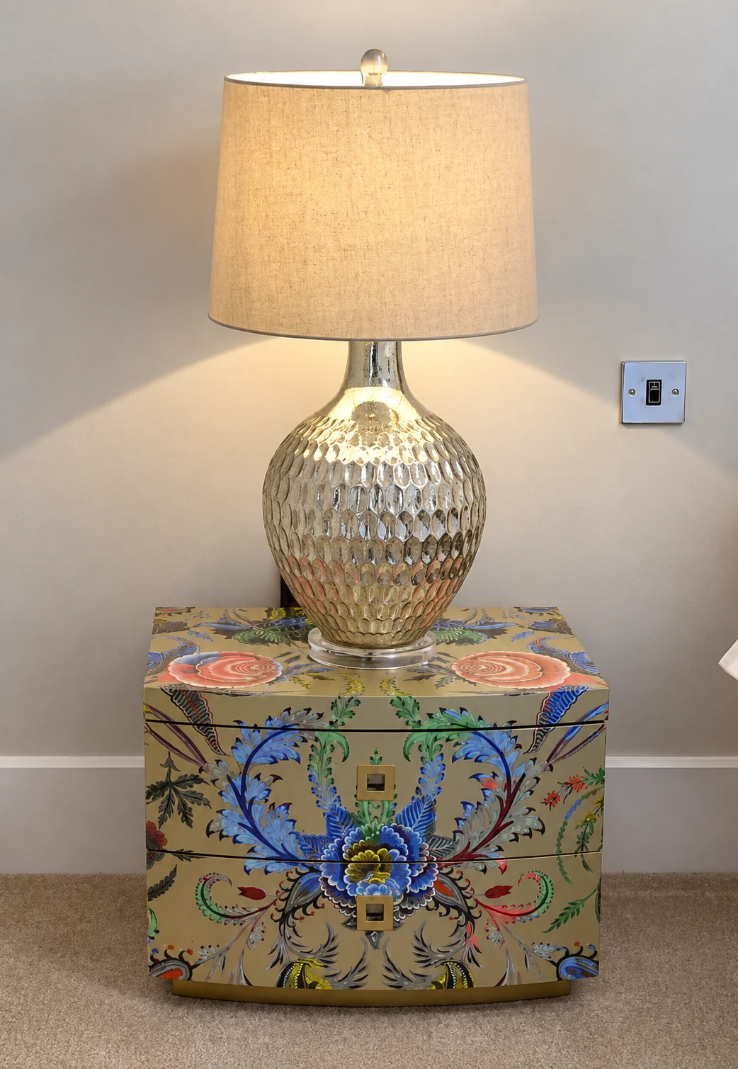 Silver lamp and colourful floral bedside drawers